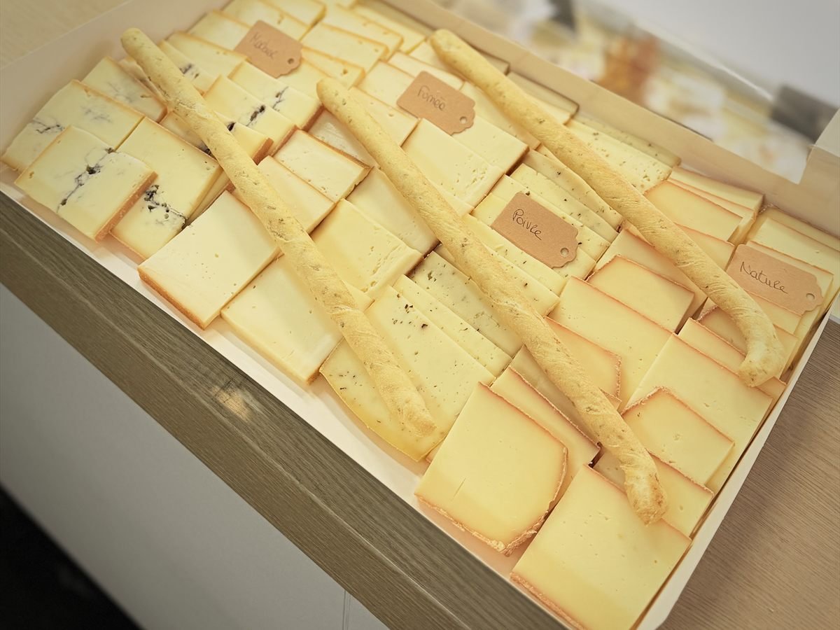 Plateau raclette en boîte, tranches disposées en rangées avec étiquettes et gressins